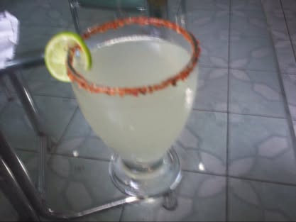 Top view of the lemonade: Tajín rim, lemon slice, on a glass table with mosaic floor